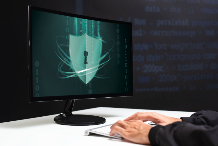 Bouclier de sécurité cybernétique sur écran, personne travaillant.
