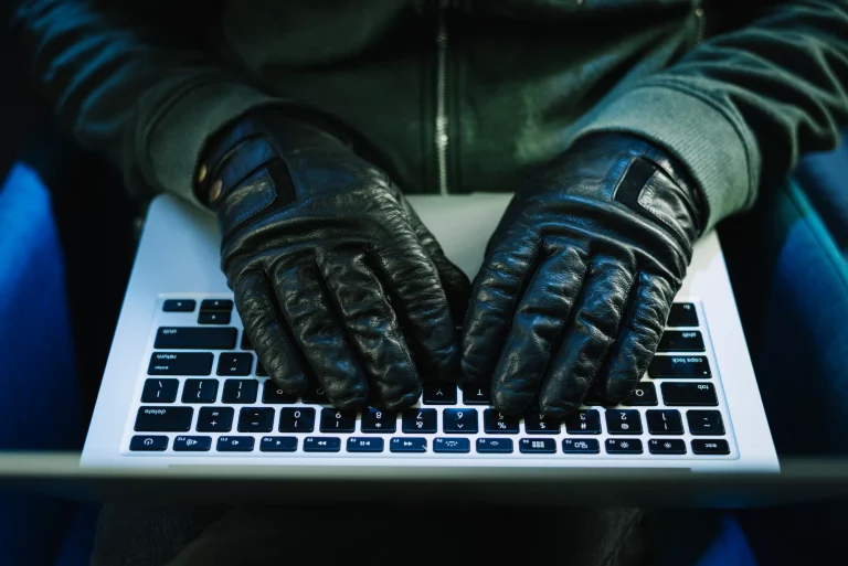 Mains en gants tapant sur un clavier d'ordinateur