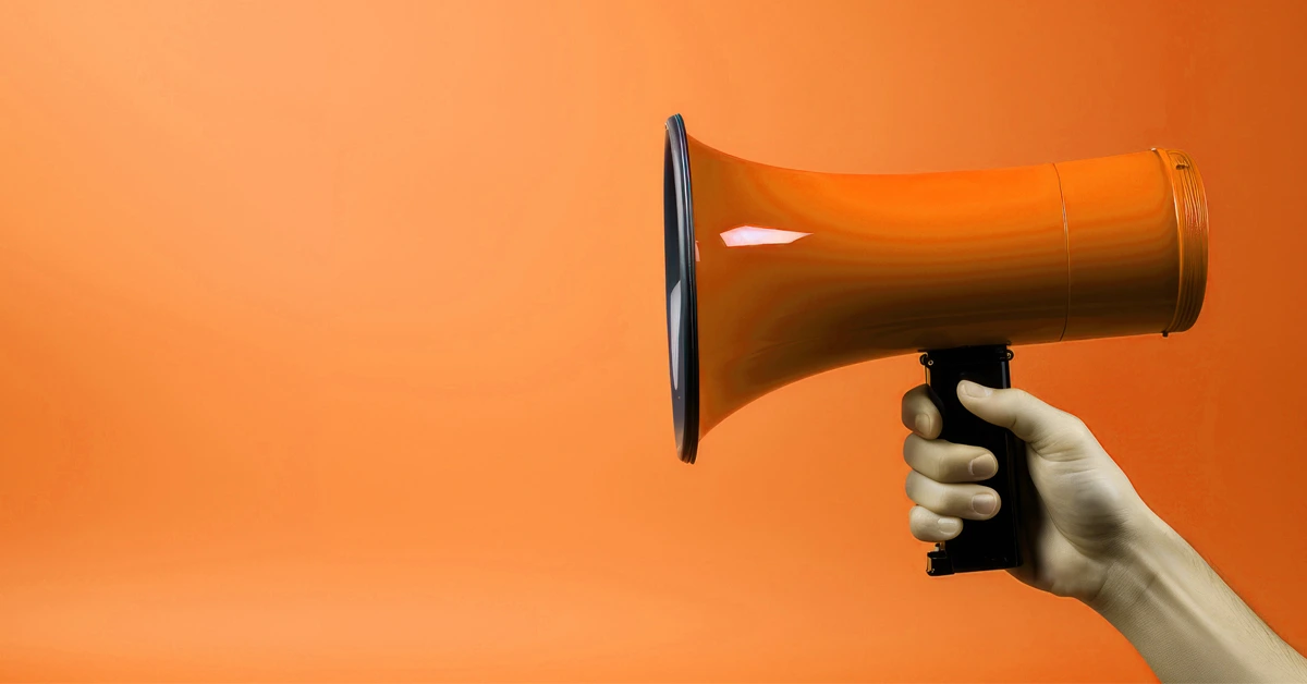 Main tenant un mégaphone sur fond orange