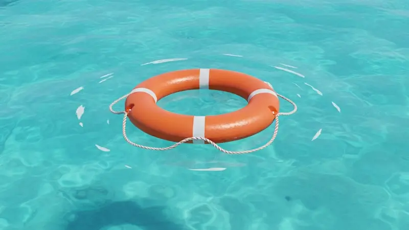 Orange lifebuoy floating in clear water