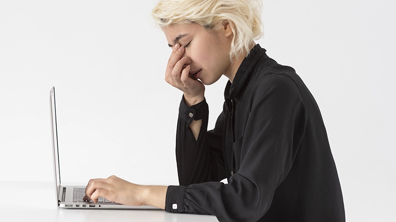 Tired person working on a laptop