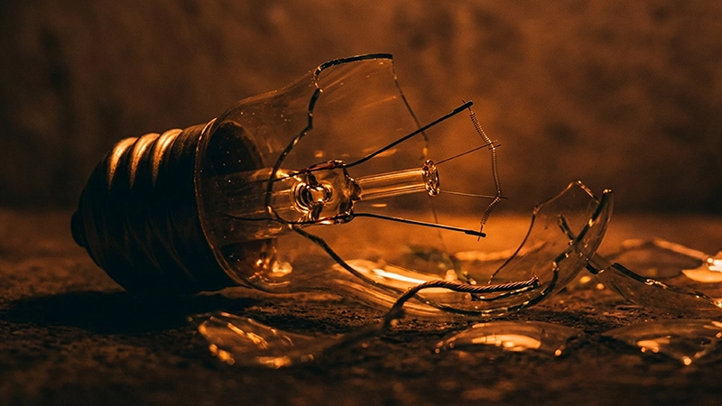 Ampoule cassée sur fond sombre