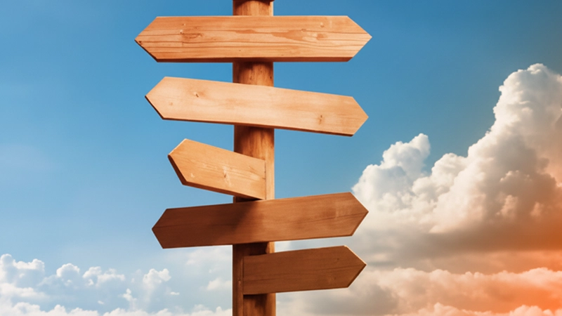 Wooden directional sign under blue sky