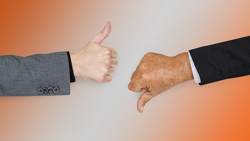 Two men's hands facing each other. One hand with a thumbs-up, the other with a thumbs-down, symbolizing contrast.<br>