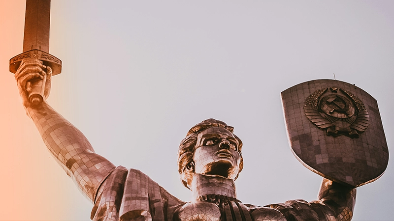 Metal statue holding a sword and shield.