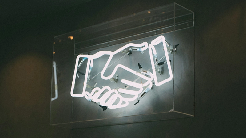 Neon handshake sign