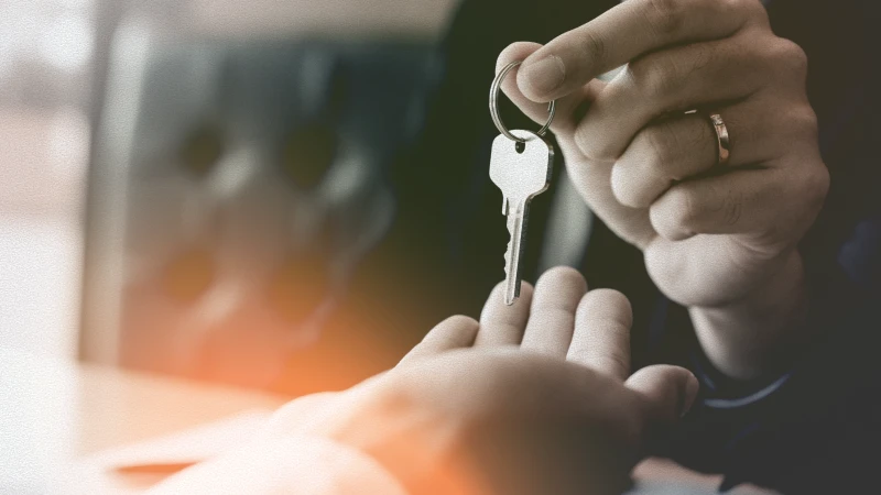 Deux mains, représentant une personne remettant une clé à une autre.