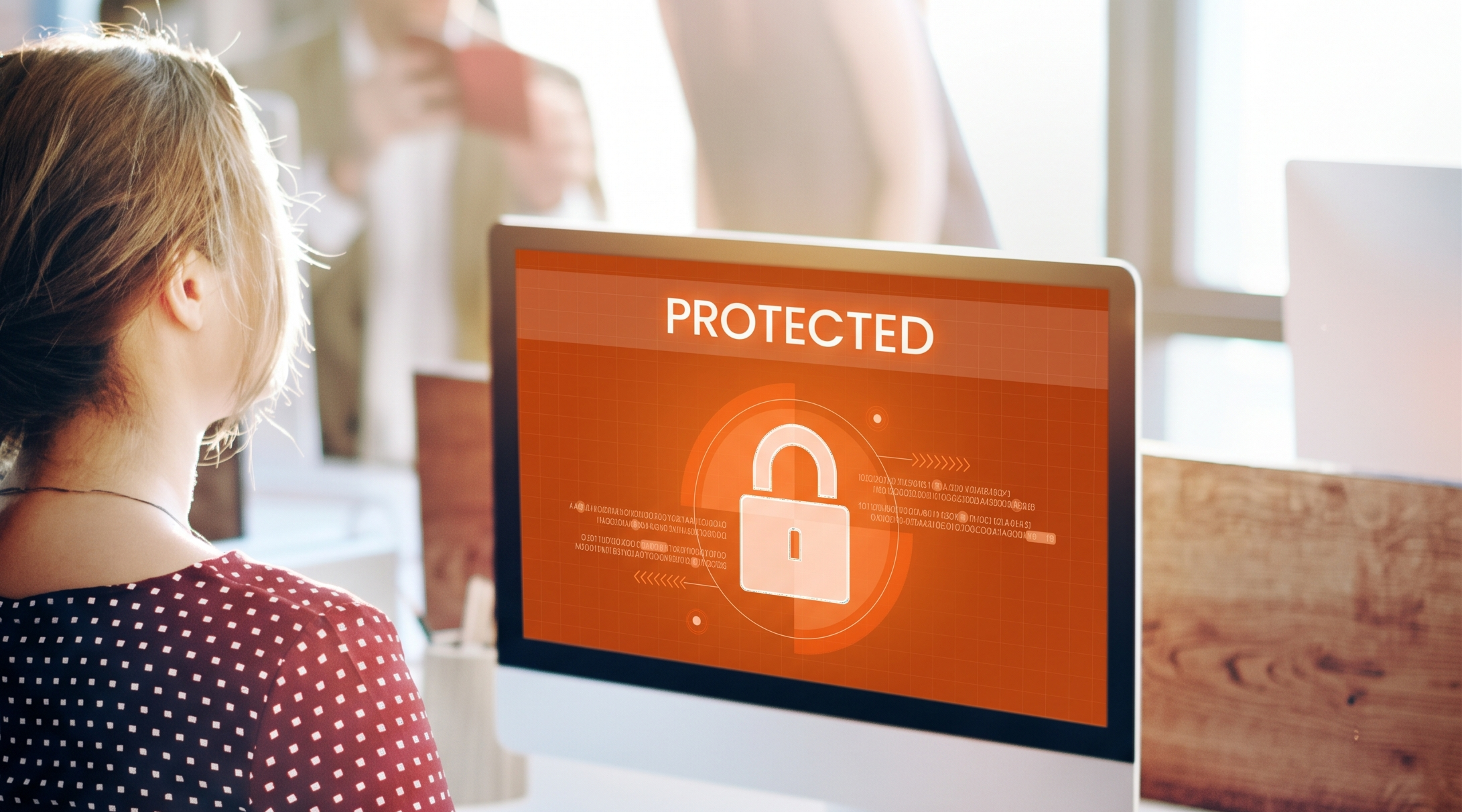Femme utilisant un ordinateur affichant un cadenas et le mot "PROTECTED" illustrant la sécurité web